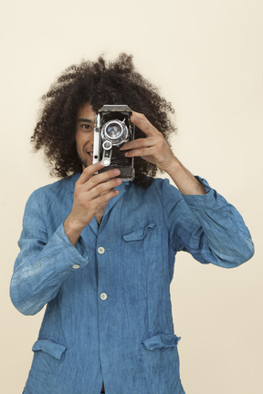 Afroman com grande cabelo encaracolado segurando uma câmera vintage