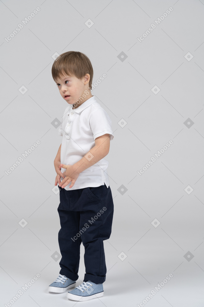 Serious-looking little boy standing
