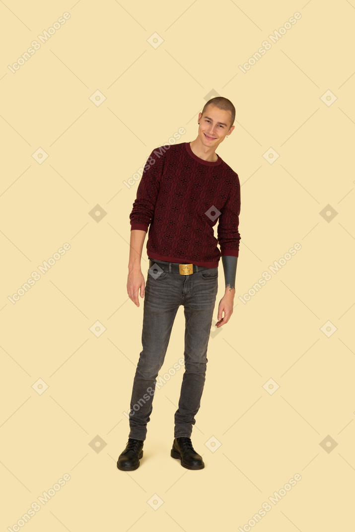 Вид спереди симпатичного улыбающегося молодого человека в красном пуловере