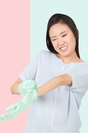 Woman putting on household gloves