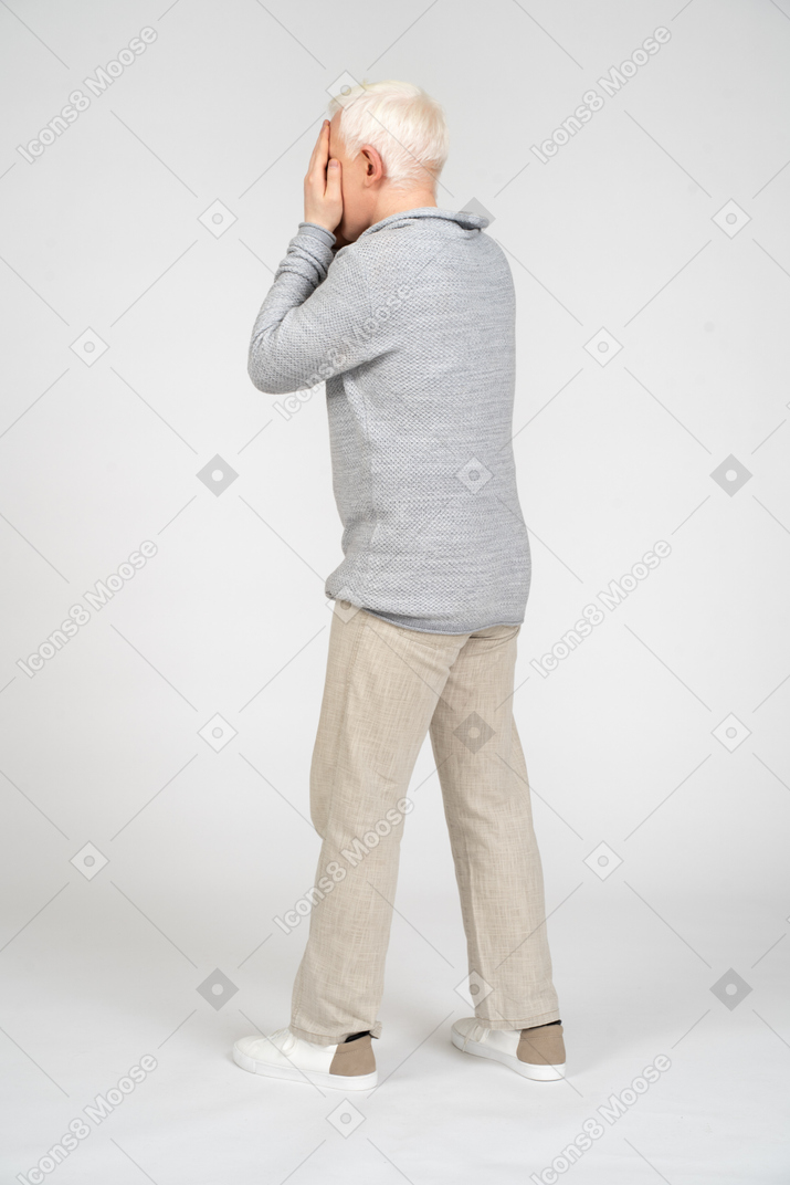 Man walking and covering his face with his hands