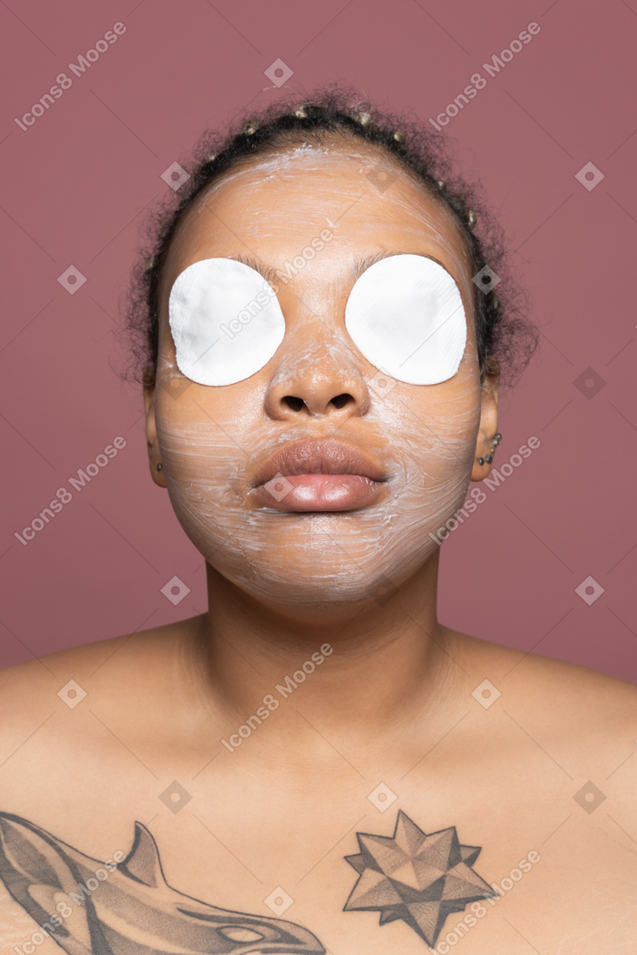 Donna afro-americana con cuscinetti per gli occhi idratanti