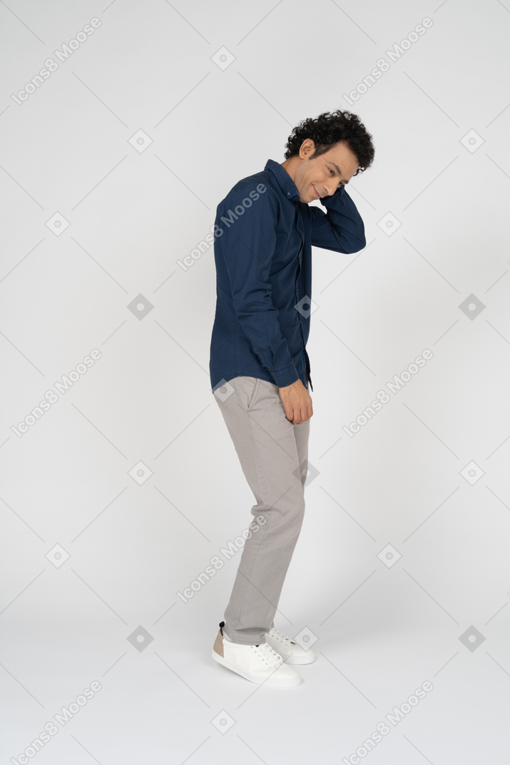 Side view of a man in casual clothes touching head