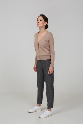 Three-quarter view of a pouting young lady in pullover and pants