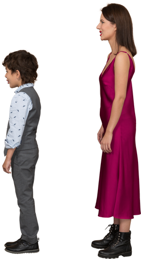 Disgusted woman in red dress and boy standing in profile