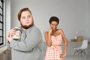 A man hiding a jar of candy from a woman