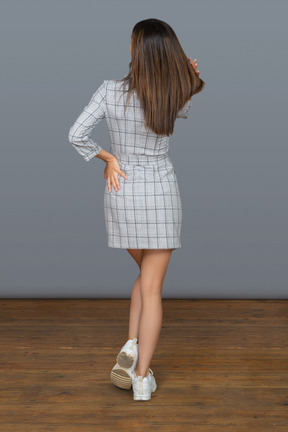 Unrecognizable brunette woman touching hair back to camera