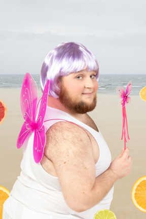 A man in a purple wig dressed as a fairy