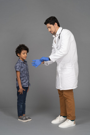 Doctor putting on blue sergical gloves