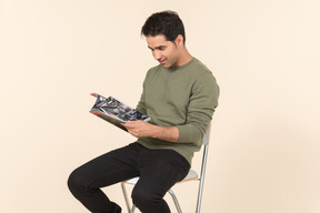 Young caucasian guy reading a comicbook