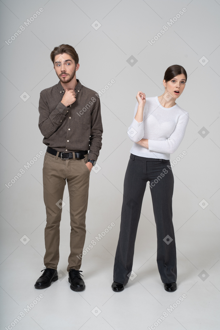 一对好奇的年轻夫妇，在办公室服装的前视图