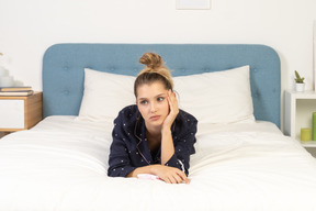 Front view of a dreaming young female touching her face