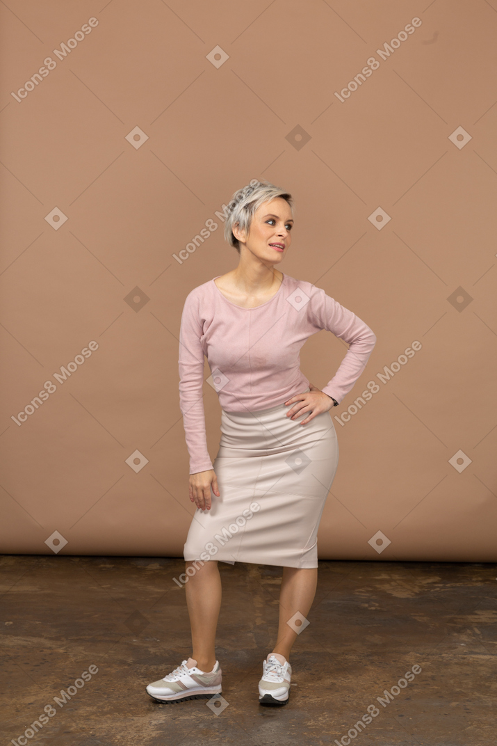 Vue de face d'une femme en vêtements décontractés posant avec la main sur la hanche