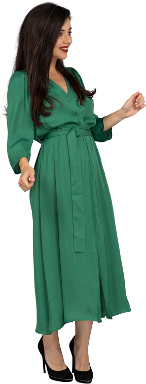 Vista di tre quarti di una giovane donna sorridente in abito verde