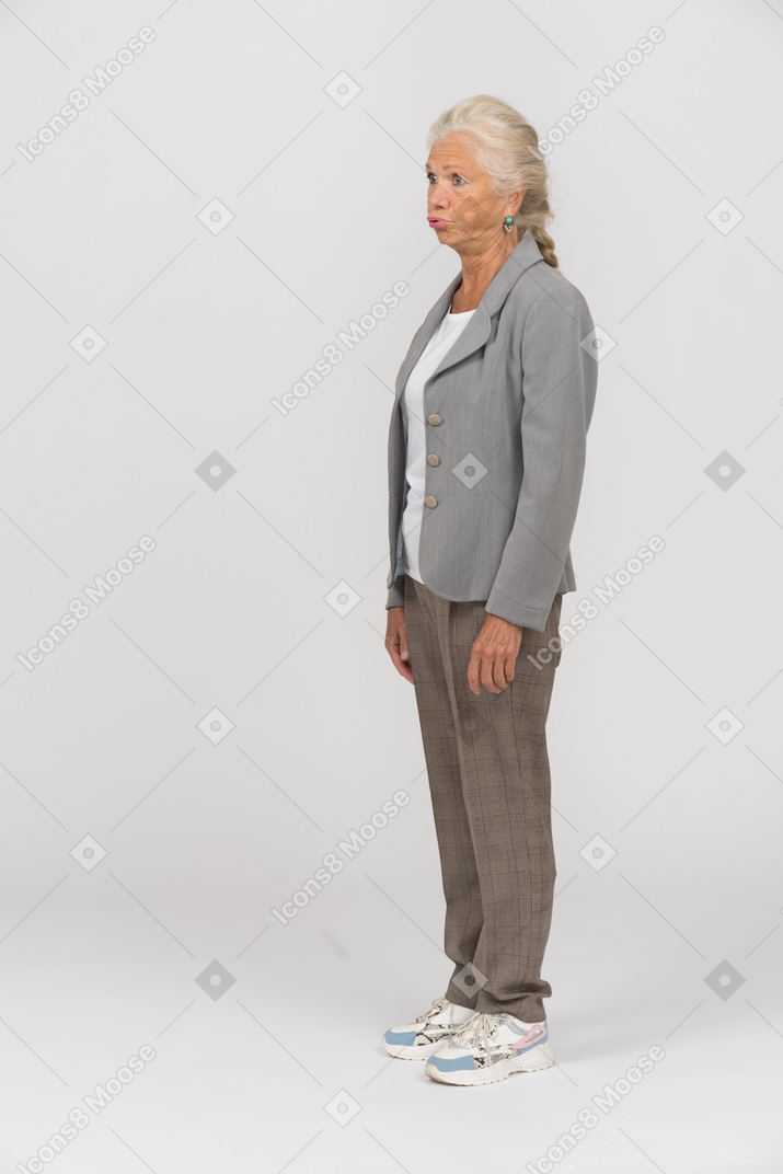 Side view of an old woman in grey jacket making faces