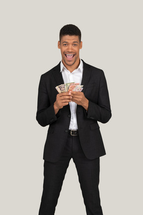 Vista di tre quarti di un giovane in abito nero che tiene banconote