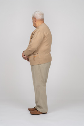 Old man in casual clothes standing in profile