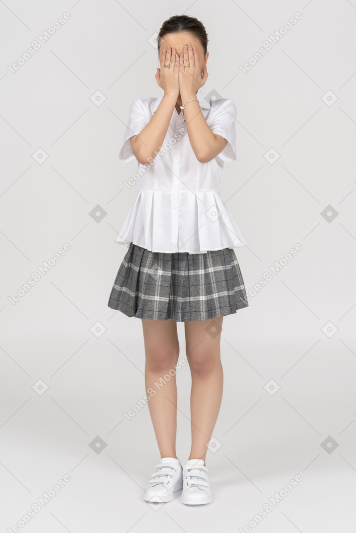 Young girl closing covering face with her hands