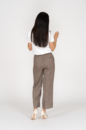 Back view of a young woman in breeches raising hand