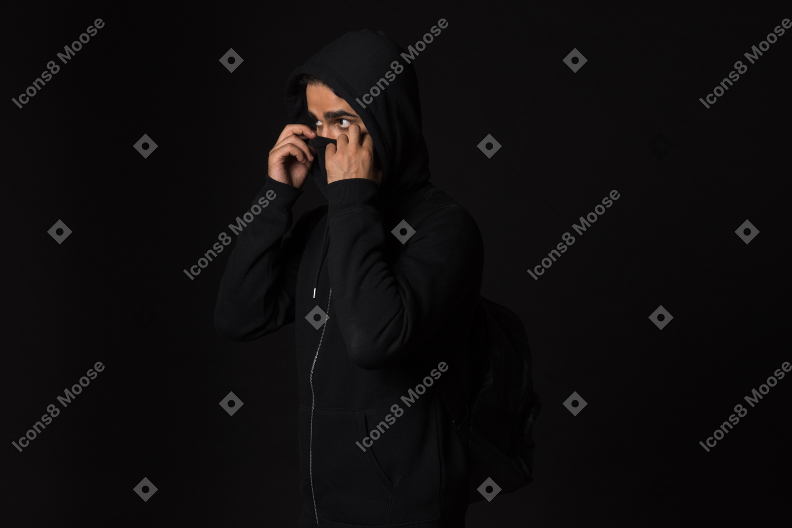 Hacker guy standing in the dark and covering his face
