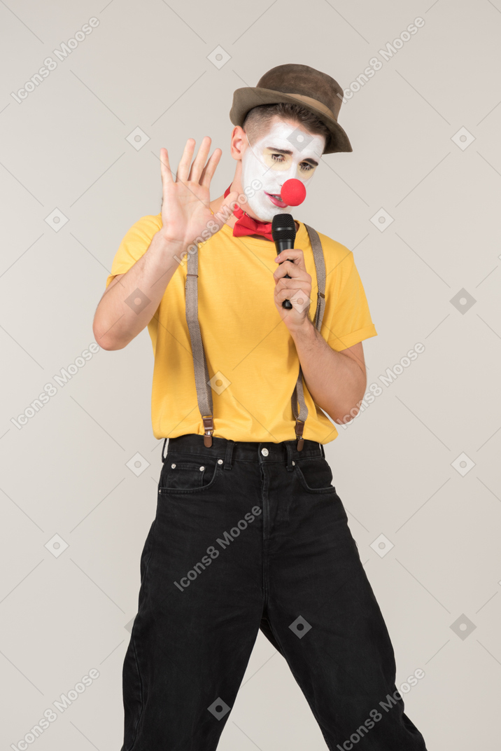 Male clown singing something into a microphone