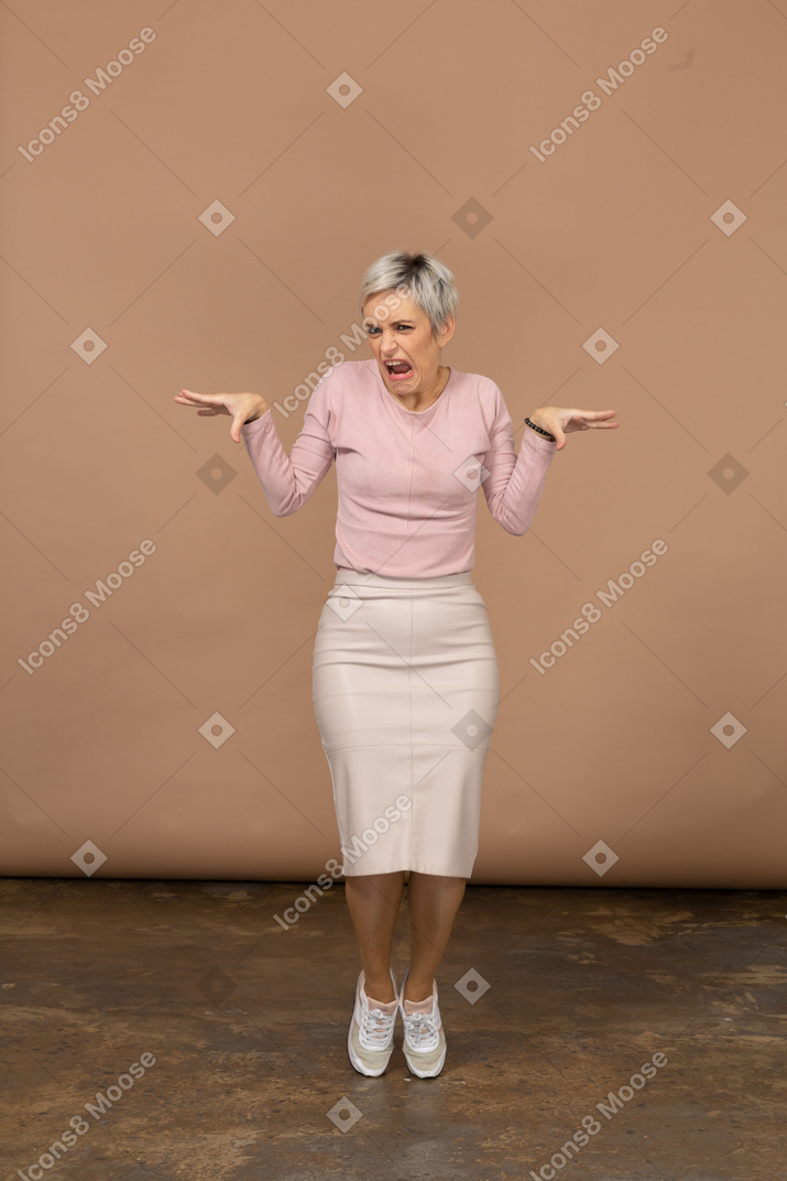 Vue de face d'une femme émotive dans des vêtements décontractés debout sur les orteils et les bras tendus