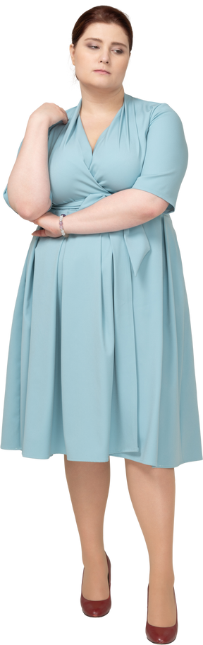 一个穿着蓝色裙子思考的悲伤女人的前视图