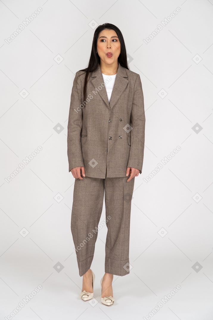 Front view of a pouting young lady in brown business suit showing tongue