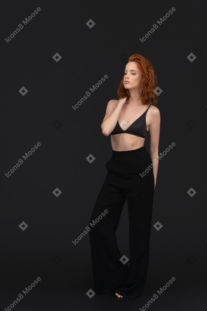 A three-quarter side view of the beautiful sexy girl dressed in black and posing