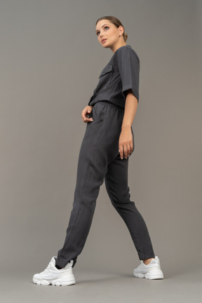 Side view of a bossy young woman in a jumpsuit