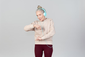 Joyful young lady in headphones dancing to music