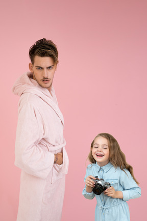 Злой молодой человек и его маленькая дочь с фотоаппаратом и смех
