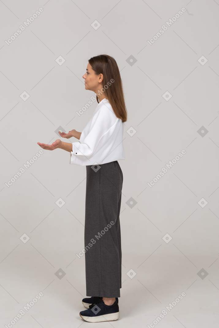 Side view of a young lady in office clothing outspreading hands