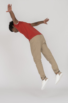 Young man falling down with spread arms