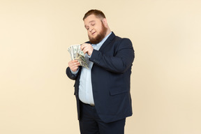 A plus-size man in a black costume with dollar bills in his hands