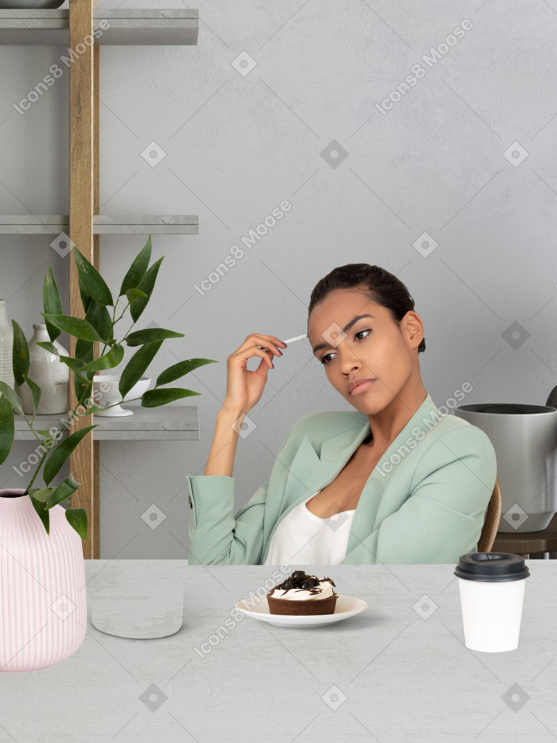 A woman sitting at a table with a plate of cake