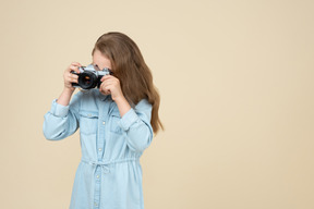 Bambina carina che tiene una macchina fotografica