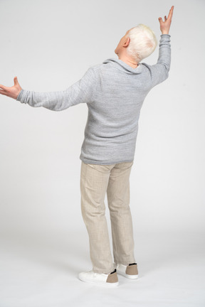 Back view of a man standing with raised arms