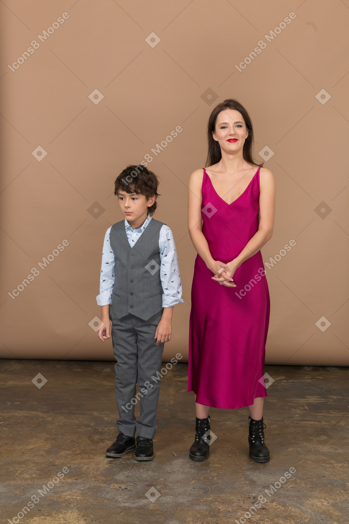 年轻女子站在一个男孩和微笑