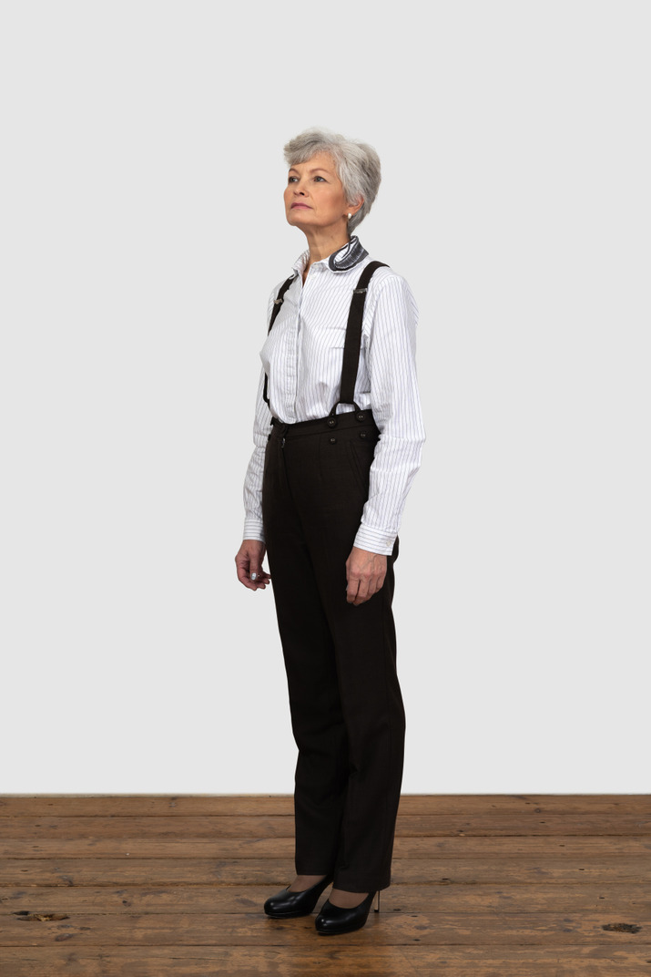 Three-quarters view of a confident old female dressed in office clothes