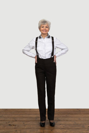 Full-length of a delighted old female in suspenders putting hands on hips