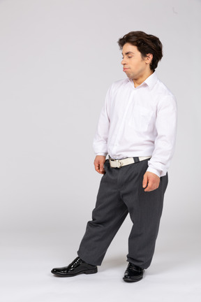 Jeune homme en vêtements de bureau debout dans une pose détendue