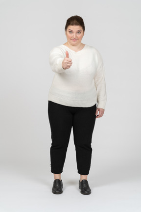 Plump woman in casual clothes showing thumb down