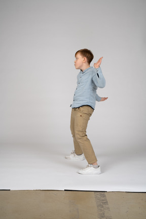 Um menino em frente a uma parede com os braços cruzados