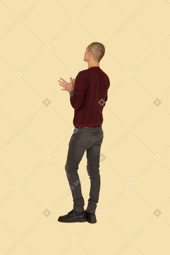 Vista posteriore di tre quarti di un uomo sconosciuto che gesticola con un maglione rosso