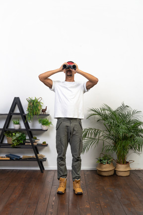 Good looking young man holding binoculars