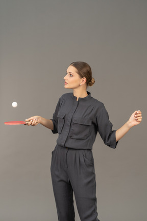 卓球をしているジャンプスーツの若い女性の正面図