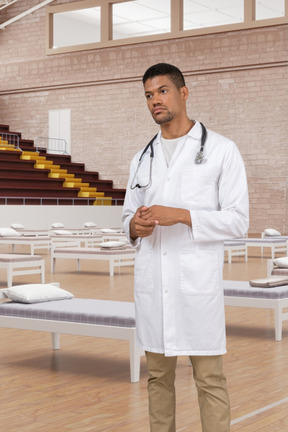 A man in a white lab coat standing in a gymnasium