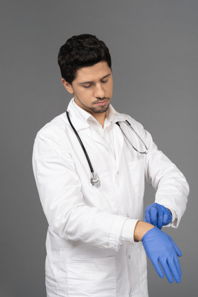 Doctor taking off his gloves