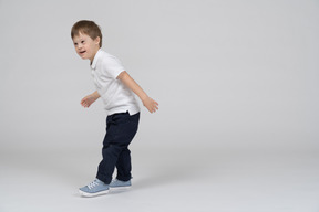 Vista lateral de un niño pequeño corriendo